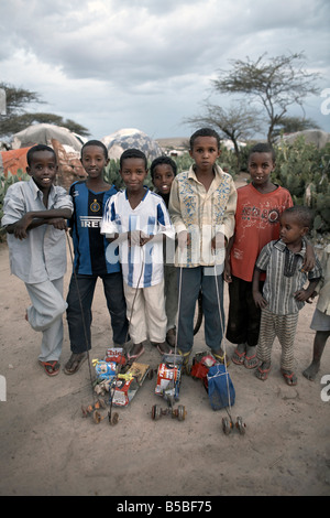 Kinder mit selbst gebastelten Spielsachen stellen in einem Internally Displaced Persons Camp in Hargesa, Somaliland, Somalia Stockfoto
