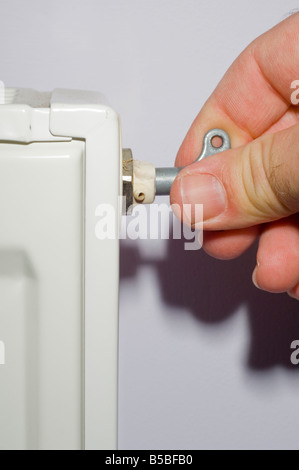 Bild zeigt Person Blutungen einen Heizkörper mit rad Schlüssel Luft aus Heizung zur Vermeidung von Kältebrücken im Heizkörper entfernen Stockfoto