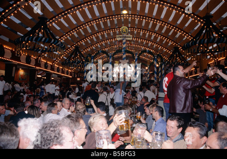 Jährliche Oktoberfest Bier großen Festspielhaus leuchtet auf Decke Menschen trinken aus Bierkrügen Liter Bierkrüge München Stockfoto