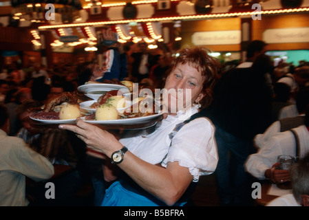 Wiesn Bierfest riesige Halle Menschen drängen sich Kellnerin Frau tragenden Tablett Essen München Stockfoto