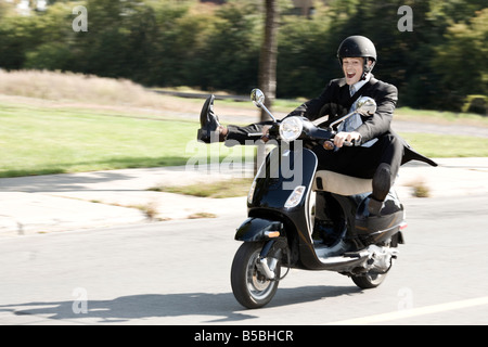 30 Jahre alten Kaukasischen Männchen tragen einen Business-Anzug ein Motorroller in Bewegung Stockfoto