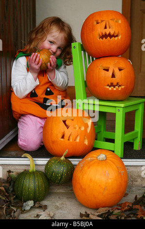 Ein Kind an Halloween verkleidet als Hexe mit ihren Kürbissen Stockfoto