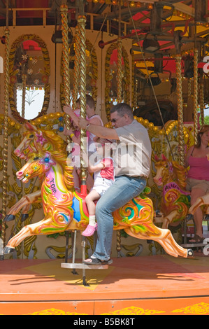 Leute Mann und Mädchen auf Kirmes Kirmes Fair Karussell Pferd Ride uk Stockfoto