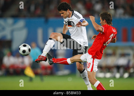 Deutschlands Michael Ballack (l) kickt den Ball während herausgefordert durch Österreichs Martin Harnik (r) während eines Spiels der UEFA Euro 2008 Stockfoto
