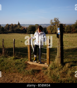 Frau zu Fuß durch einen Stil. Sundridge, Kent, England, UK. Stockfoto