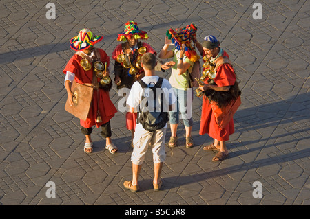 3 Männer in traditioneller Kleidung als Wasserträger für eine touristische Kamera am Djemaa El Fna - der Hauptmarkt-Quadrat Marrakes darstellen Stockfoto