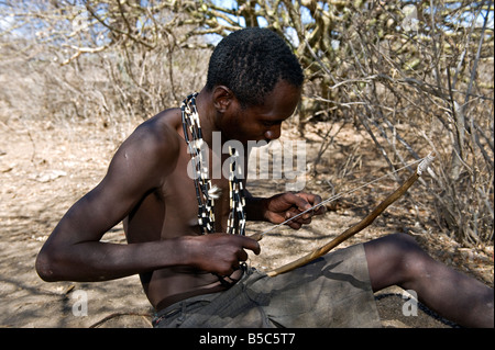 Ein Mann des Stammes Hadza macht einen Jagdbogen Lake Eyasi-Tansania Stockfoto