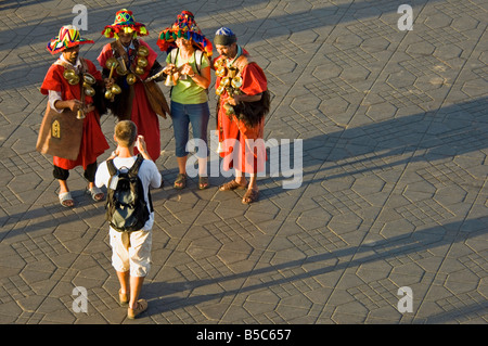 3 Männer in traditioneller Kleidung als Wasserträger für eine touristische Kamera am Djemaa El Fna - der Hauptmarkt-Quadrat Marrakes darstellen Stockfoto