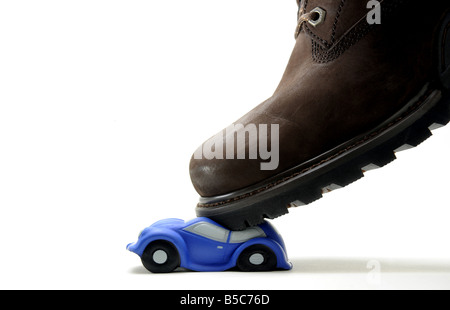 EIN MODELLAUTO ZERQUETSCHT UNTER A MANS BOOT. Stockfoto