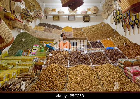 Ein Ladenbesitzer verkaufen, getrockneten Früchten, Nüssen und Gewürzen aus seinem kleinen Geschäft im Bereich Souk von Marrakesch. Stockfoto