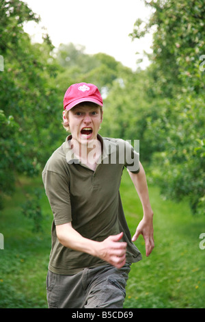 Teenager junge 15 Jahre alt läuft in Apple Orchard schreien Stockfoto