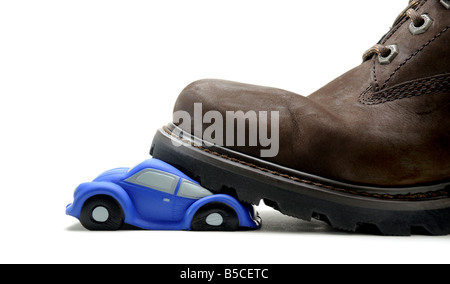 EIN MODELLAUTO ZERQUETSCHT UNTER A MANS BOOT. Stockfoto