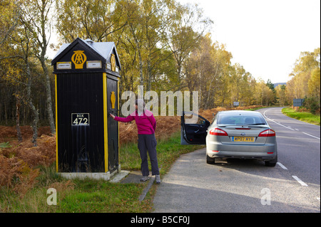 Frau sich öffnende Tür, AA Telefonzelle Schottland, Vereinigtes Königreich Stockfoto