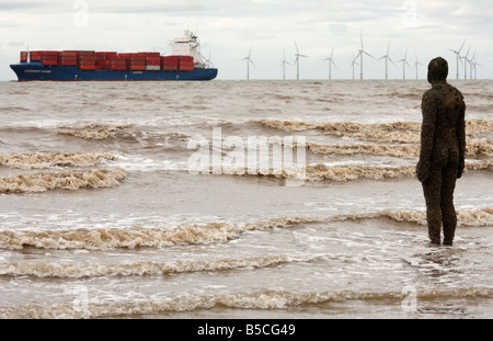 Antony Gormley Skulptur des Menschen im Meer mit Blick auf die vorbeifahrenden Schiff und "Burbo Bank" "Windparks offshore", Crosby Beach, England, UK Stockfoto