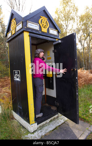 Frau Türöffnung auf AA Handy eine Anruf Box Scotland UK zu machen Stockfoto