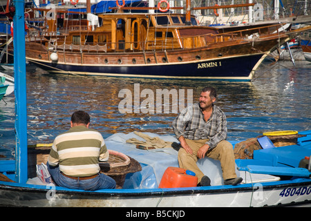 Zwei türkische Fischer sitzen in einem kleinen Fischerboot im Mittelmeer bei Fethiye Türkei Stockfoto