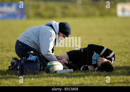 Physiotherapeuten kümmert sich um verletzte Rugbyspieler Stockfoto