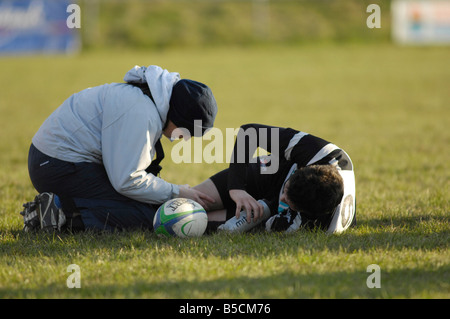 Physiotherapeuten kümmert sich um verletzte Rugbyspieler Stockfoto