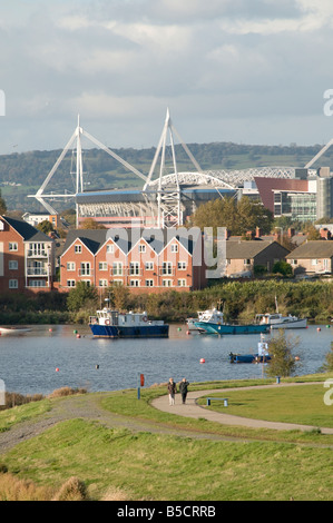 Boote in der Nähe Wasser-Häuser und Wohnungen mit Cardiff City Skyline aus der Bucht mit dem Millennium Stadium, Wales UK gesehen Stockfoto