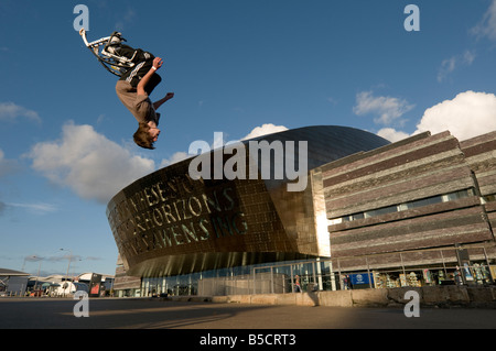 Teenager, die Durchführung Purzelbaum akrobatische Stunts auf bouncy Pogo Stelzen außerhalb das Wales Millennium Centre Cardiff UK Stockfoto