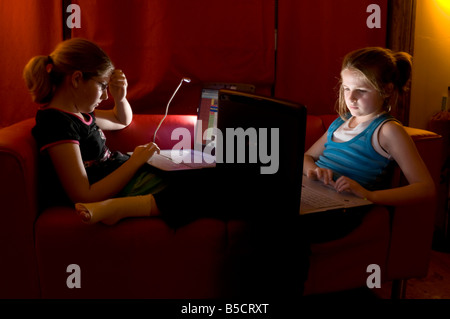 Zwei junge Mädchen-Schwestern mit dem Laptopcomputer chatten mit ihren Freunden über MSN und andere social-Networking-Websites Stockfoto