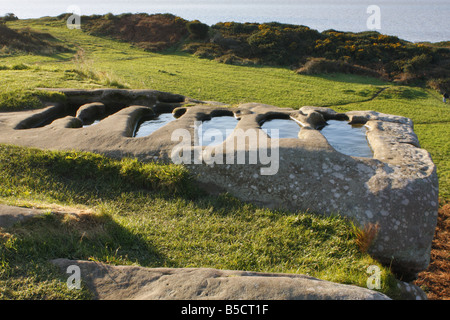 Frühen christlichen Felsen gehauene Gräber gefüllt mit Regenwasser auf einem Sandstein von St Patricks Kapelle Stockfoto