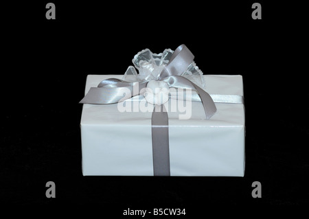 Geschenkbox mit Silberband auf schwarzem Hintergrund ein Engagement Partyüberraschung mit einem Apcket von Jordanien Mandeln geschmückt weiß Stockfoto
