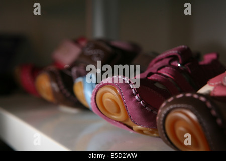 Einige Kinder Schuhe auf einem Regal nebeneinander aufgereiht. Stockfoto