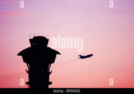 Verkehrsflugzeug zieht bei Abenddämmerung, Kontrollturm der Los Angeles International Airport Stockfoto