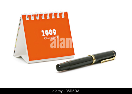 Mini-Schreibtisch Top Kalender und Füllfederhalter isoliert auf weißem Hintergrund Stockfoto