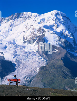 Wanderer auf Bank, das Breithorn und Breithorn Gletscher, Rotenboden, Zermatt, Wallis, Schweiz, Europa Stockfoto