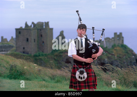 Pfeifer, vor Dunnotar Castle aus dem 14. Jahrhundert, in der Nähe von Stonehaven, Aberdeenshire, Schottland, Europa zu spielen Stockfoto