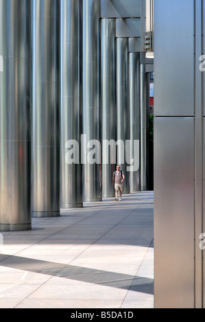 Young Man zu Fuß durch One Canada Square, Canary Wharf Estate, London, UK Stockfoto