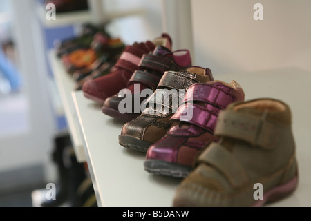 Einige Kinder Schuhe auf einem Regal nebeneinander aufgereiht. Stockfoto