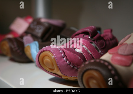 Einige Kinder Schuhe auf einem Regal nebeneinander aufgereiht. Stockfoto