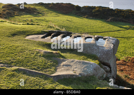 Frühen christlichen Felsen gehauene Gräber gefüllt mit Regenwasser auf einem Sandstein von St Patricks Kapelle Stockfoto