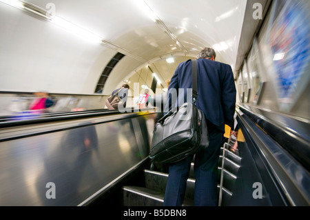 Ein Geschäftsmann auf Rolltreppe u-Bahnstation, London, England Stockfoto