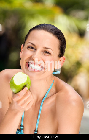 Junge Frau im Bikini mit Apfel, lächelnd, Nahaufnahme Stockfoto