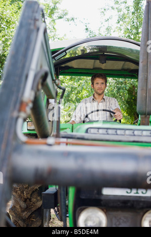 Landwirt in Traktor sitzen Stockfoto