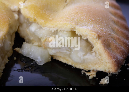 Nahaufnahme eines irischen Bramley Apfelkuchen Kuchen mit Scheibe auf einer schwarzen Platte herausgenommen Stockfoto