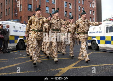 Mitglieder des Royal Irish Regiment RIR parade bei der Heimkehr aus dem Irak und Afghanistan im Stadtzentrum von Belfast, flankiert von PSNI Landrovern für die Sicherheit Stockfoto