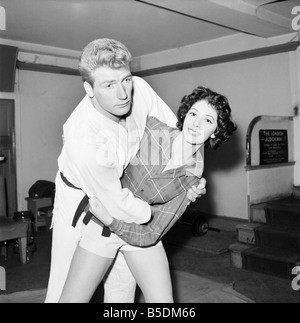 Frauen Verteidigung: Judo Experte Joe Robinson zeigt Valerie Dave einige Selbstverteidigung bewegt sich auf einen willigen Freiwilligen. Februar 1957 Stockfoto