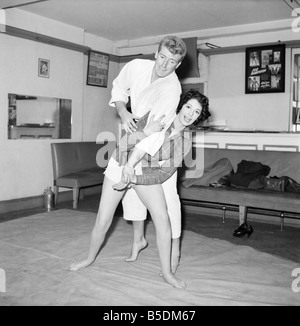 Frauen Verteidigung: Judo Experte Joe Robinson zeigt Valerie Dave einige Selbstverteidigung bewegt sich auf einen willigen Freiwilligen. Februar 1957 Stockfoto