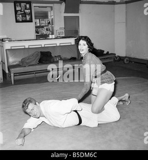 Frauen Verteidigung: Judo Experte Joe Robinson zeigt Valerie Dave einige Selbstverteidigung bewegt sich auf einen willigen Freiwilligen. Februar 1957 Stockfoto