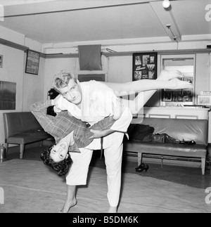 Frauen Verteidigung: Judo Experte Joe Robinson zeigt Valerie Dave einige Selbstverteidigung bewegt sich auf einen willigen Freiwilligen. Februar 1957 Stockfoto