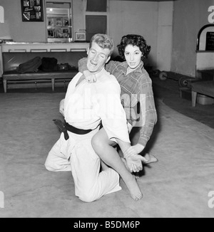 Frauen Verteidigung: Judo Experte Joe Robinson zeigt Valerie Dave einige Selbstverteidigung bewegt sich auf einen willigen Freiwilligen. Februar 1957 Stockfoto