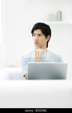 Mann hält Kinn und wegsehen Stockfoto