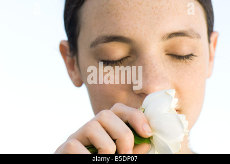 Junge Frau, die duftenden weißen rose Blossom, geschlossenen Augen, Nahaufnahme Stockfoto