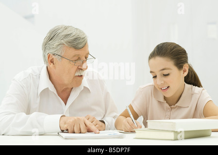 Großvater helfen Enkelin bei den Hausaufgaben Stockfoto