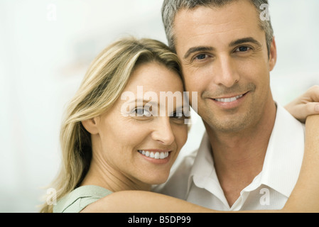 Paar lächelnd in die Kamera, Frau einwickeln Arme um Mann, Porträt Stockfoto